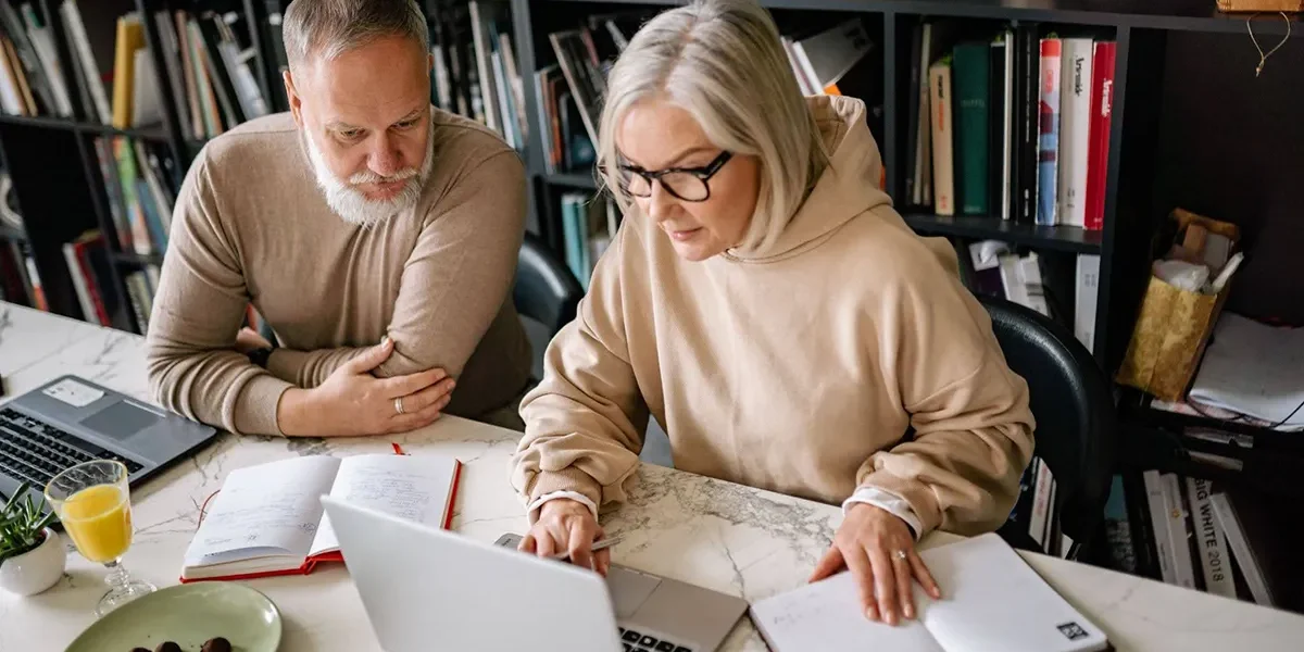 Senior couple collaborating on laptops in a cozy home office setting