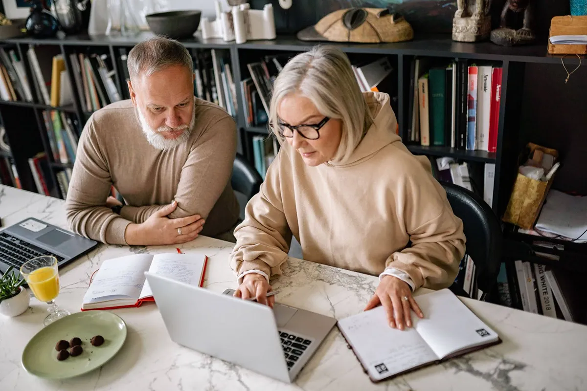 Senior couple collaborating on laptops in a cozy home office setting